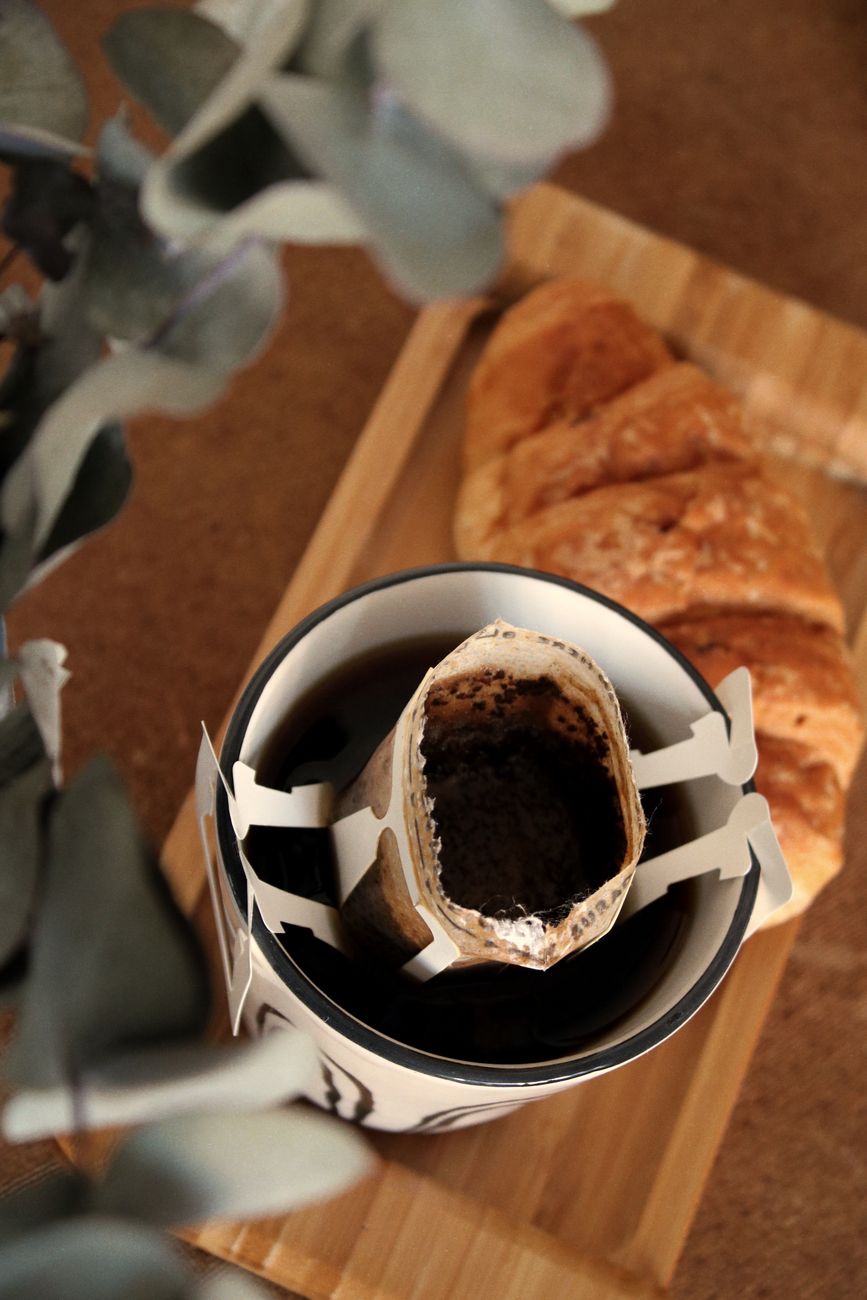 Artisan croissant next to a slow bar brew V60 decanter